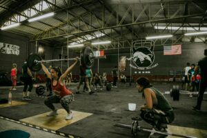 Diverse group engaging in CrossFit training in an industrial-style gym.